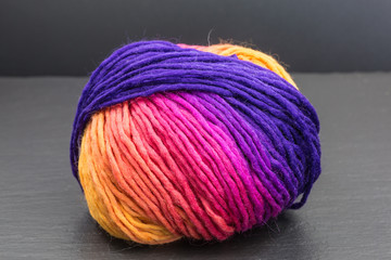 ball of multicolored wool in yellow, orange, pink and purple
