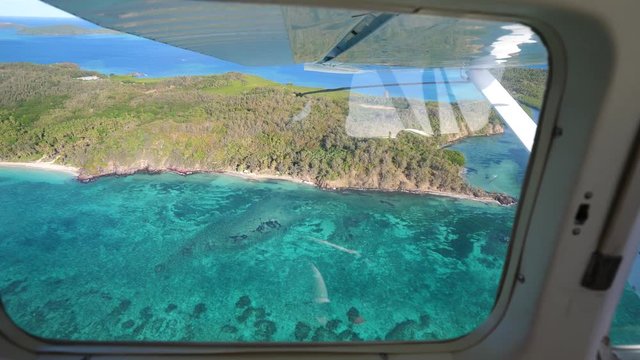Seaplane flying over Fiji Matacavalewu island and turquoise sea