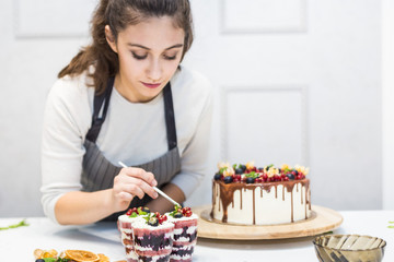 Decoration of the finished dessert. Pastry chef sprinkles confectionery with yellow powder. The concept of homemade pastry, cooking cakes.