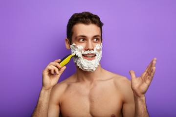 happy guy using shaving cream and looking at copy space. place for text. desensittizing of skin