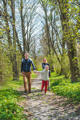 family of three walking by park trail in sunny day