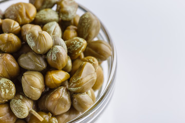 Pickled capers on a white acrylic background