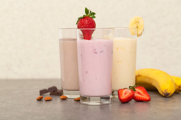 Assorted protein cocktails. Strawberry, banana and chocolate protein shakes. Sports nutrition and healthy lifestyle concept.   