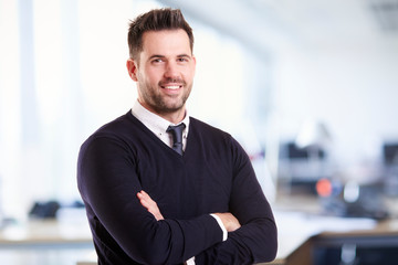 Businessman standing with folded arms in the office