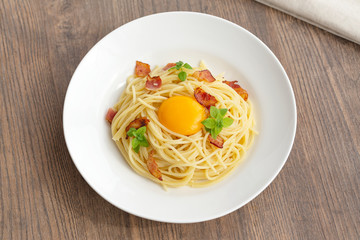 Carbonara pasta, spaghetti with pancetta, egg, hard parmesan cheese, basil and cream sauce. Traditional italian cuisine. 