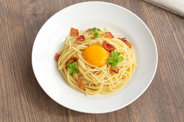 Carbonara pasta, spaghetti with pancetta, egg, hard parmesan cheese, basil and cream sauce. Traditional italian cuisine. 