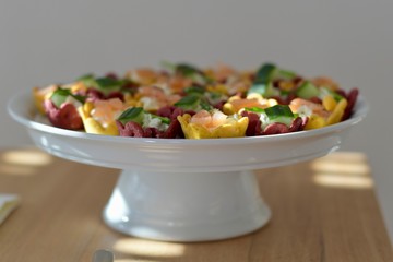 cream cheese in colored jar dough decorated with herbs on a plate on table