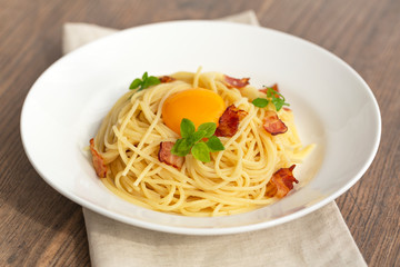 Carbonara pasta, spaghetti with pancetta, egg, hard parmesan cheese, basil and cream sauce. Traditional italian cuisine. 