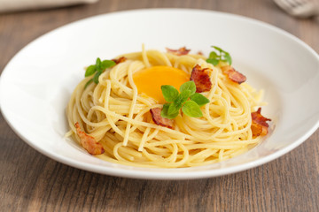 Carbonara pasta, spaghetti with pancetta, egg, hard parmesan cheese, basil and cream sauce. Traditional italian cuisine. 