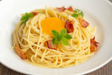 Carbonara pasta, spaghetti with pancetta, egg, hard parmesan cheese, basil and cream sauce. Traditional italian cuisine. 