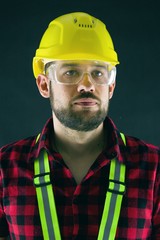 Construction Worker isolated on black background. Construction worker with yellow crash helmet....