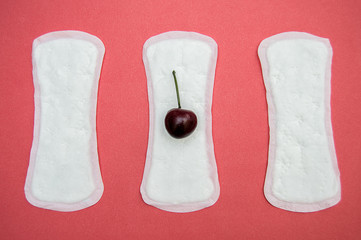 women's sanitary pads and cherry on pink background