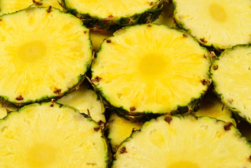 Pineapple juicy yellow slices background. Top view.