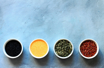 herbs, cereals and seeds in a bowl on a gray concrete background