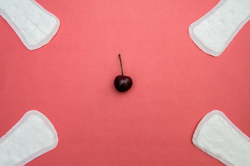 women's sanitary pads and cherry on pink background