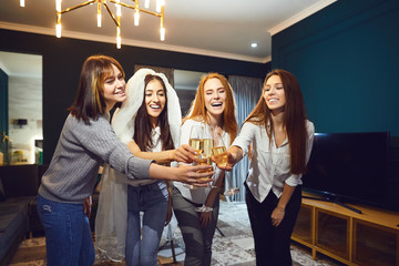 Bride and happy bridesmaids celebrating hen-party with glasses champagne
