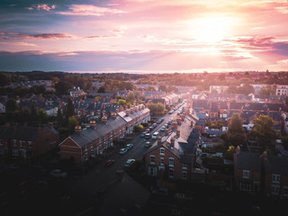 Sun rising above a traditional British housing estate with countryside in the background. Very typically English houses that are over 100 years old.