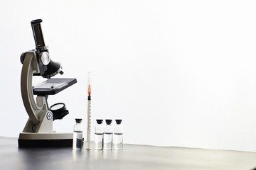 Research laboratory. Test tubes and microscope on the table on a white background.
