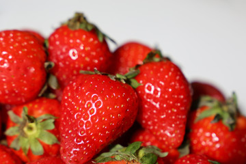 Fresh strawberries with leaves on a white background. Red strawberry close-up