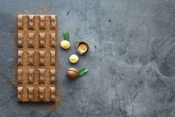 A bar of milk chocolate on the table. Chocolate with nuts and cinnamon.