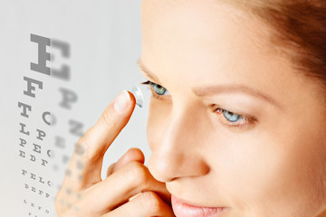 Young woman puts contact lens in her eye. Eyewear, eyesight and vision, eye care and health,...