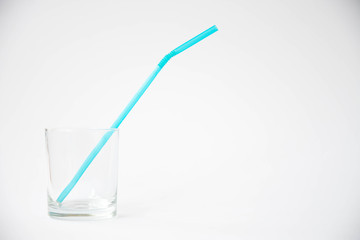 The glass with plastic tube on white background. Art soft focus