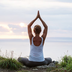 Caucasian woman practicing yoga at seashore