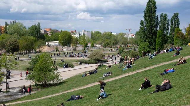People on meadow  in crowded public park (Mauerpark) on a sunny day in Berlin, Prenzlauer Berg