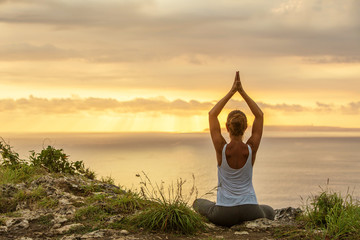 Caucasian woman practicing yoga at seashore