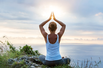 Caucasian woman practicing yoga at seashore