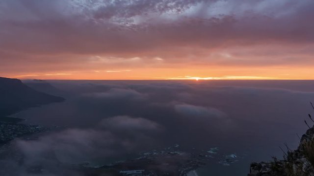 landscape time lapse of sunset with colorful clouds and beatiful coastline from above on Lions Head in Cape Town South Africa