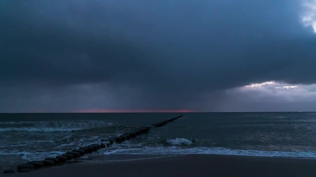 landscape timelapse of sunrise at the beach with rain clouds and rainfall