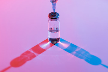 Glass bottle with vaccine and syringe for injection.