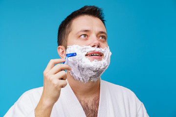 Photo of man in white coat shaving