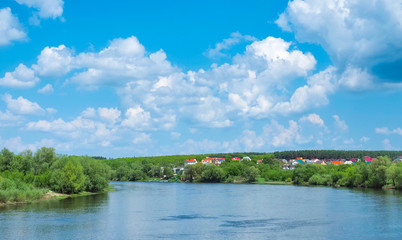 wide river with houses and beautiful clouds