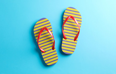 Flip flops on color background, space for text. Summer vacation backdrop