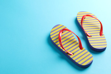 Flip flops on color background, space for text. Summer vacation backdrop