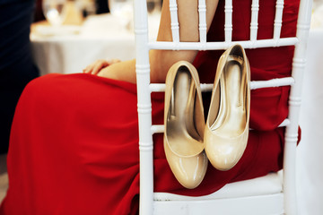 shoes on the back of a chair in a restaurant. Swelling of feet in high heel shoes. Copy space for your text 