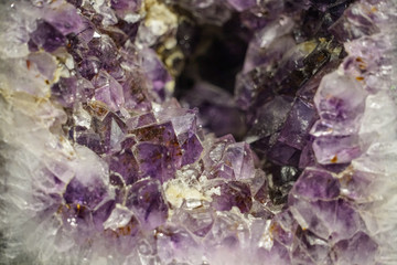 Amethyst cluster rough crystals close up in low light background
