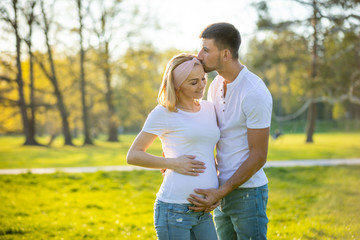 Happy couple expecting baby, pregnant woman with husband, young family and new life concept