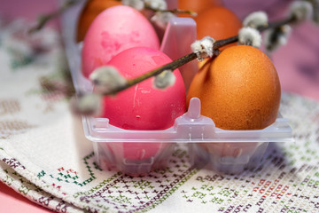 Painted eggs for Easter, pink, beige, painted in onion husks. Willow, spring, towel with ornaments. Easter holiday.