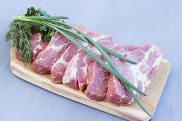 Raw pork steaks on a wooden board. Fresh pork meat prepared for grilling.