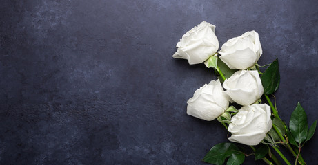 White rose flowers bouquet on black stone background