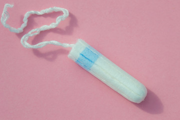 Hygienic tampon on a pink background close-up.