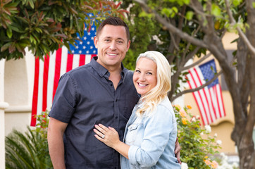 Fototapeta premium Happy Couple In Front of Houses with American Flags