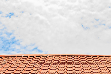 Red roof with a cloudy blue sky on top