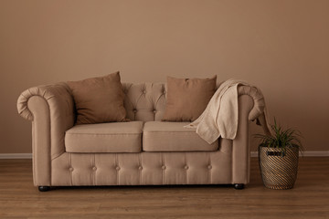 Beautiful beige textile sofa chesterfild in the interiors of the room