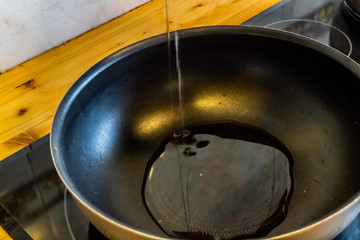 pouring olive oil from Spain, in a black pan