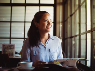 Asian woman drinking coffee in cafe