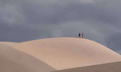 Fototapeta na wymiar People at the top of the dunes at the Alexandria coastal dune fields near Addo / Colchester on the Sunshine Coast in South Africa. 